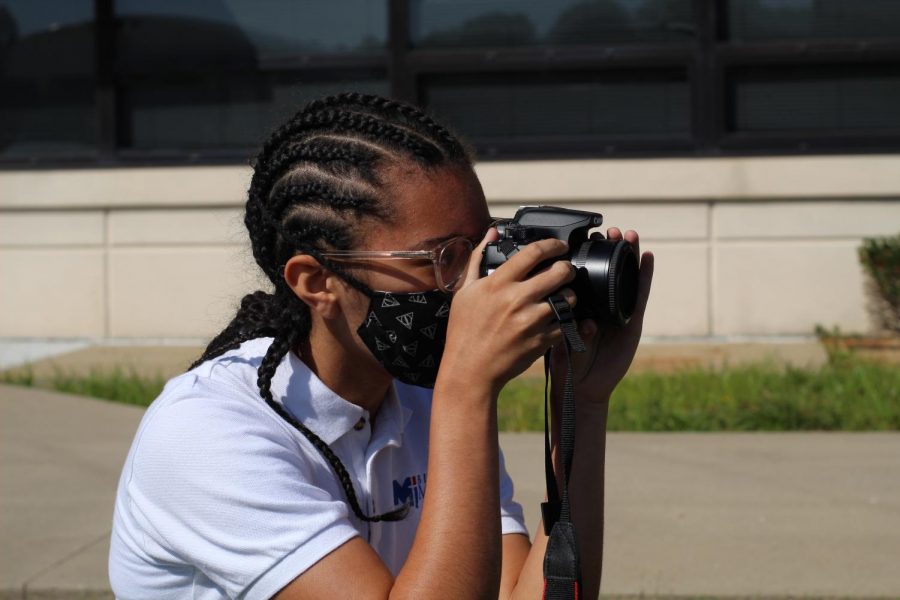 Students practice their photography skills outside in the sunshine. 